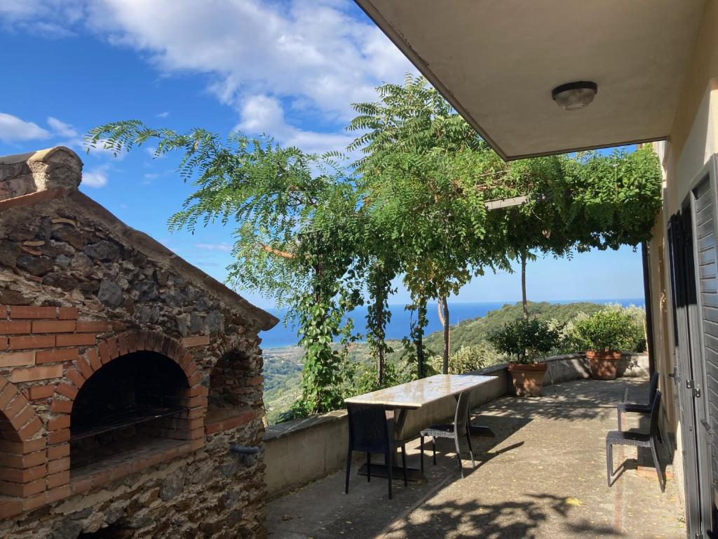 un patio con mesa y horno de ladrillo en Villa en Nocera Terinese