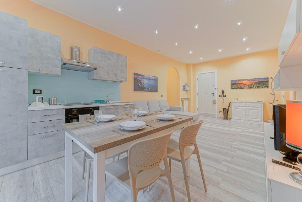 Genova Sturla Elegant Apartment في جينوا: مطبخ مع طاولة وكراسي خشبية كبيرة
