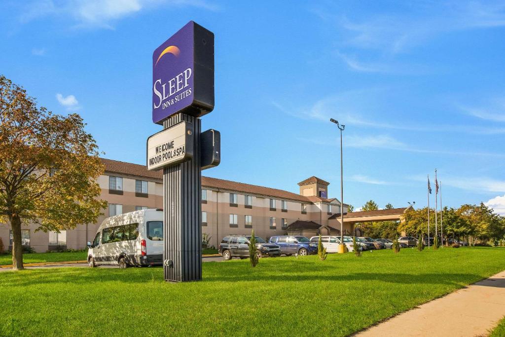 a street sign in the grass in front of a building at Sleep Inn & Suites in Grand Rapids