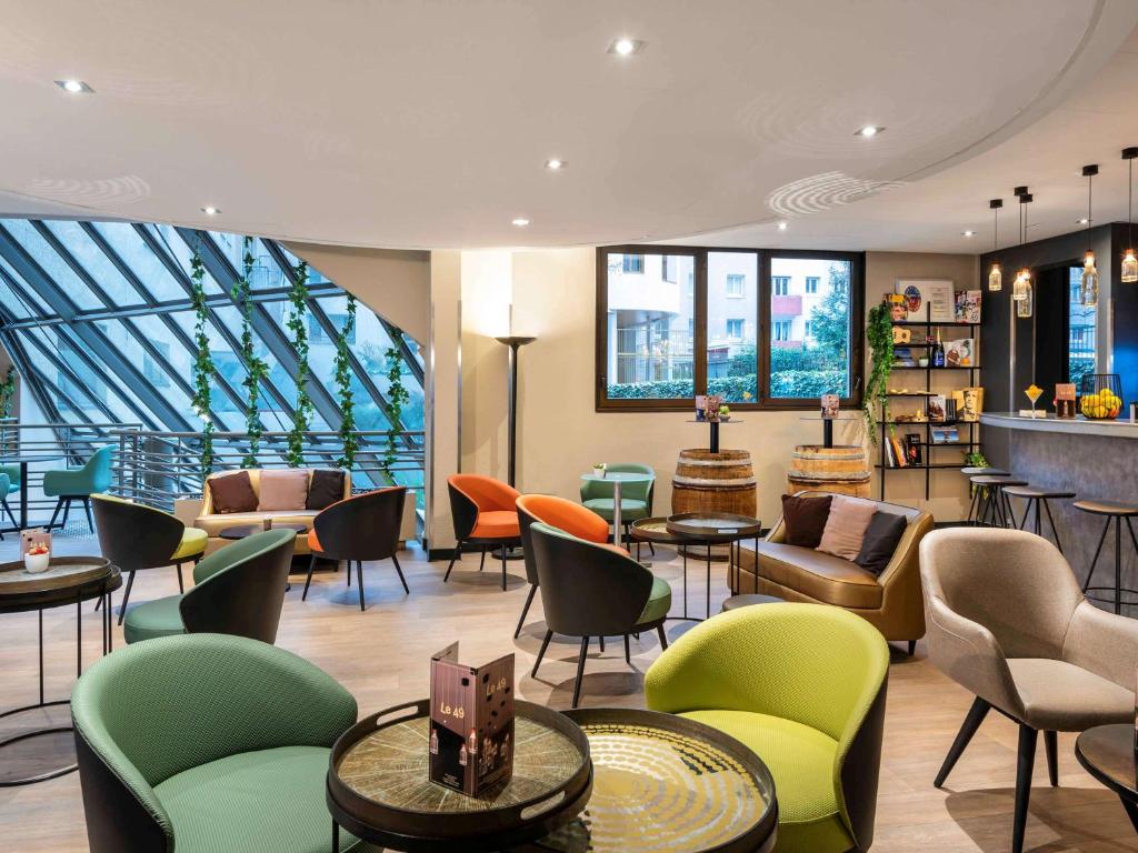 a lobby with chairs and tables in a building at ibis Paris Alesia Montparnasse in Paris