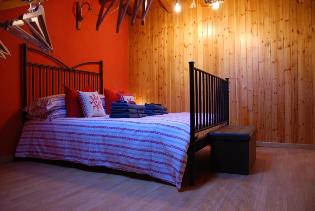 een slaapkamer met een bed en een houten muur bij Zia Letizia in Nus