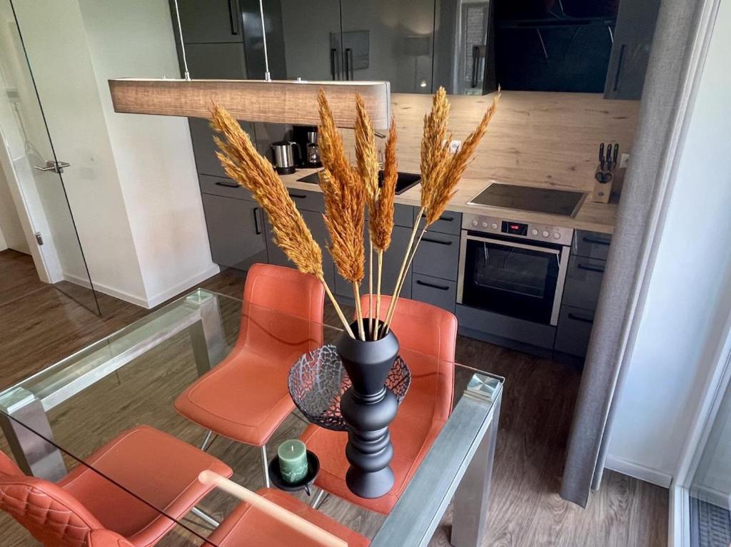 a kitchen with a table with a vase with grass at Dahmer Strand 7 in Dahme