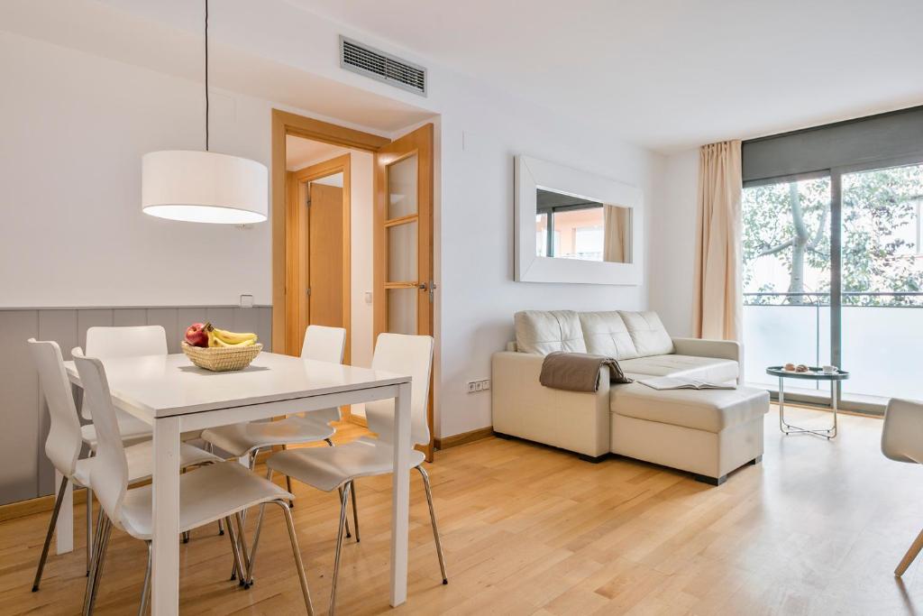 ein Esszimmer und ein Wohnzimmer mit einem weißen Tisch und Stühlen in der Unterkunft Inside Barcelona Apartments Princep in Barcelona