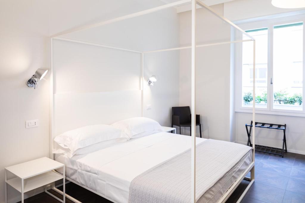 um quarto branco com uma cama de dossel e uma janela em flaminia354 - Alloggio Turistico em Roma