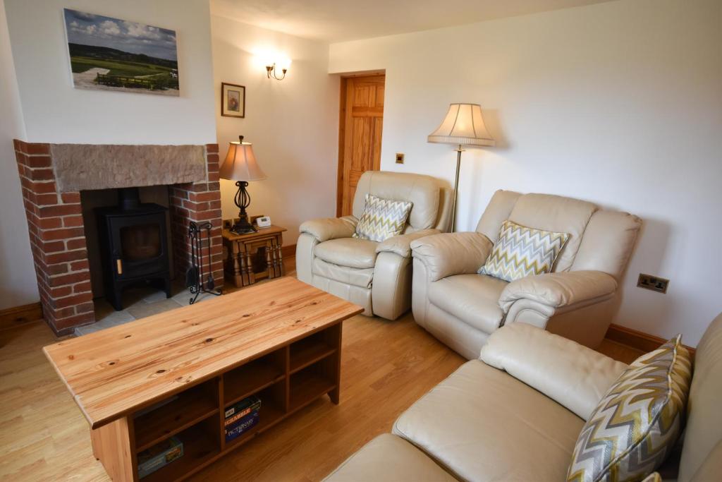 a living room with two couches and a fireplace at The Cottage, Poplars Farm in Ashbourne