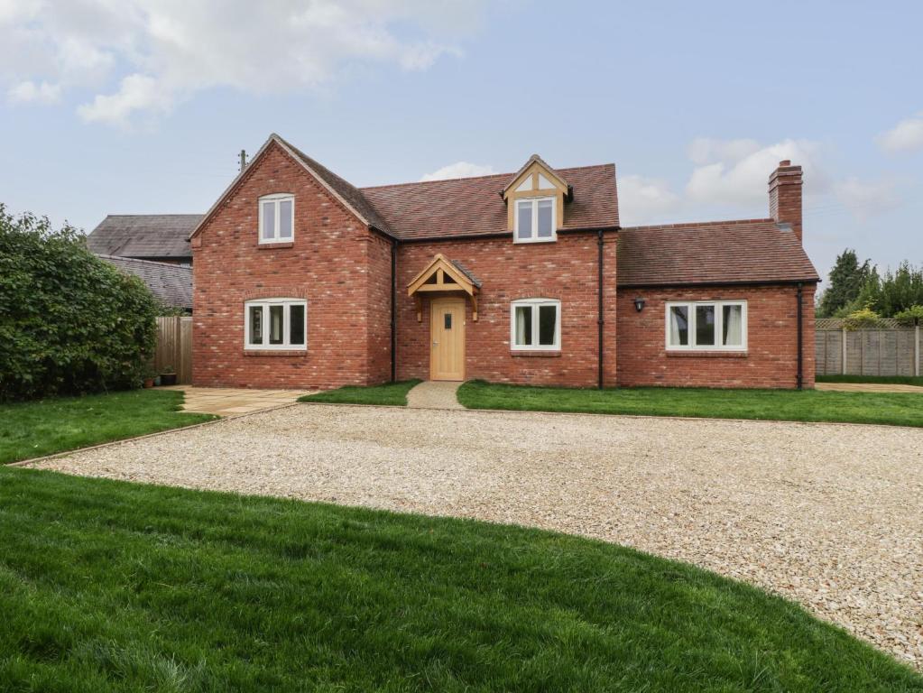 a large brick house with a gravel driveway at Oakdene in Stratford-upon-Avon