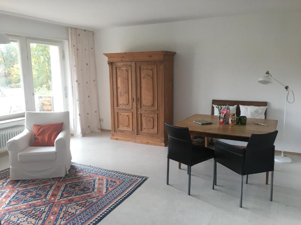 a living room with a wooden table and chairs at Ferienwohnung Kliniknähe mit Blick ins Grüne in Tübingen