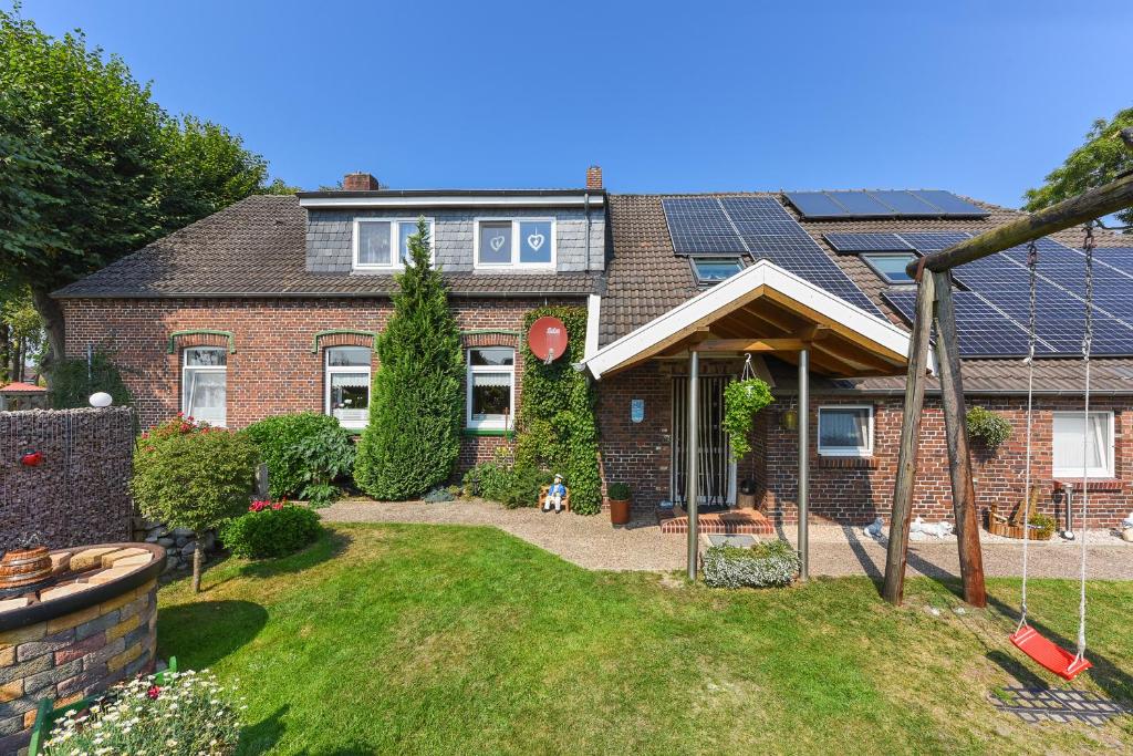 a large brick house with a yard with a yard at Ferienwohnungen im Landhaus Oldenhof in Stedesdorf