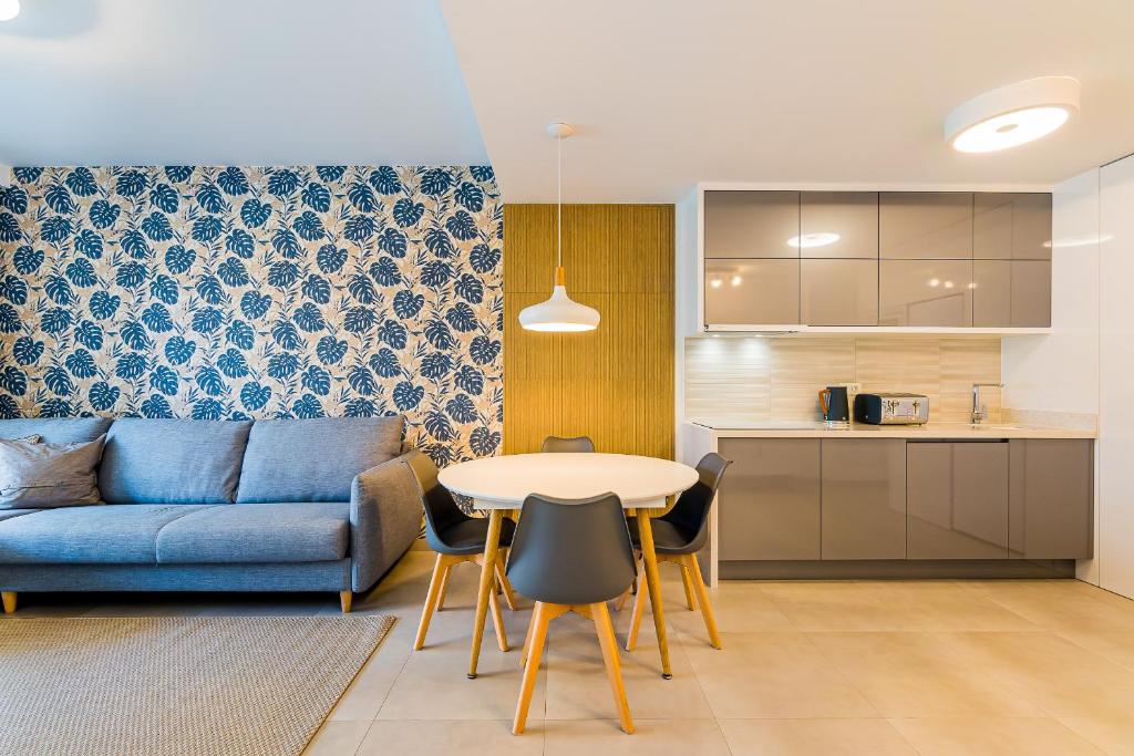 uma sala de estar com um sofá, uma mesa e uma cozinha em High class 2 Bedroom Apartment with underfloor heating em La Horadada