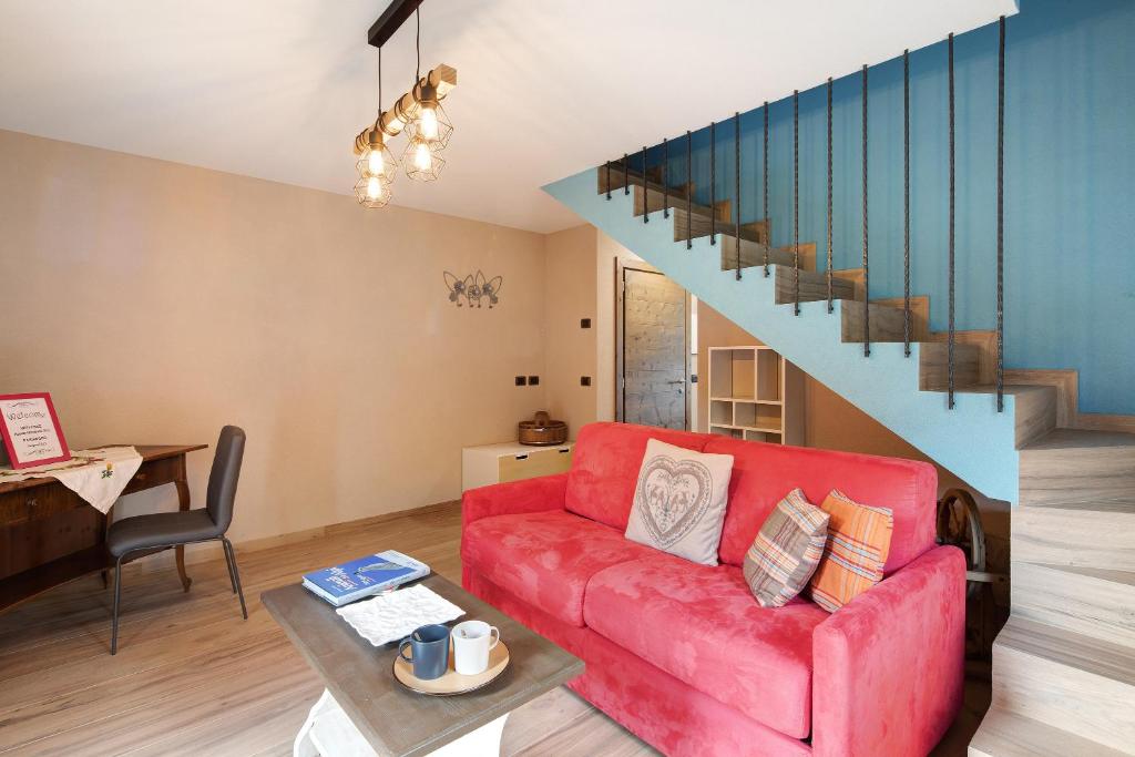 ein Wohnzimmer mit einem roten Sofa und einer Treppe in der Unterkunft Appartamento Livigno in Livigno