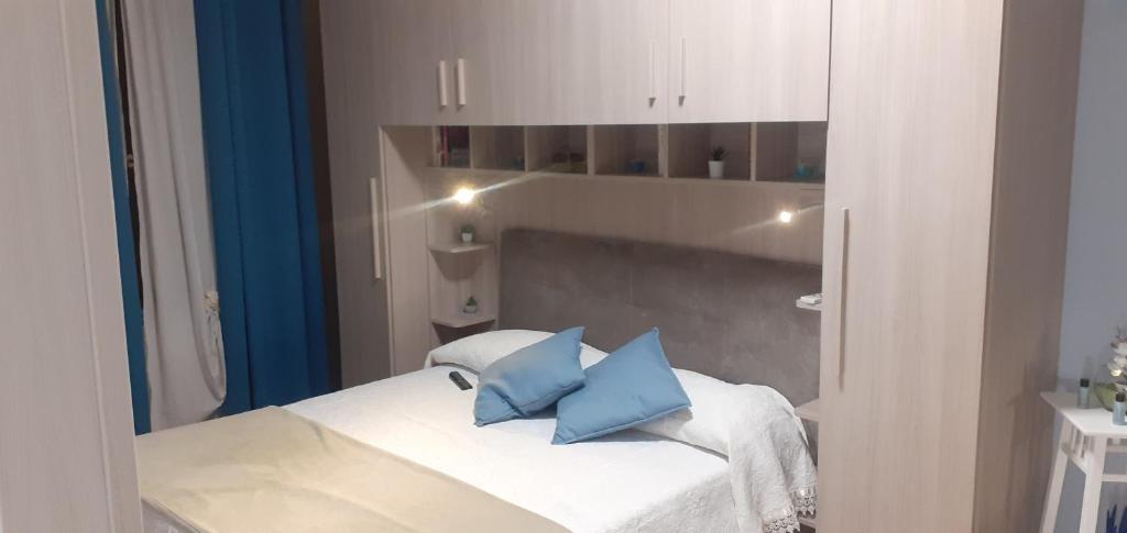 a bedroom with a bed with blue pillows on it at ORCHIDEA in Montella