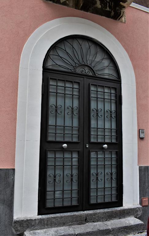 czarne drzwi na różowym budynku w obiekcie Casa Nirè II w Katanii