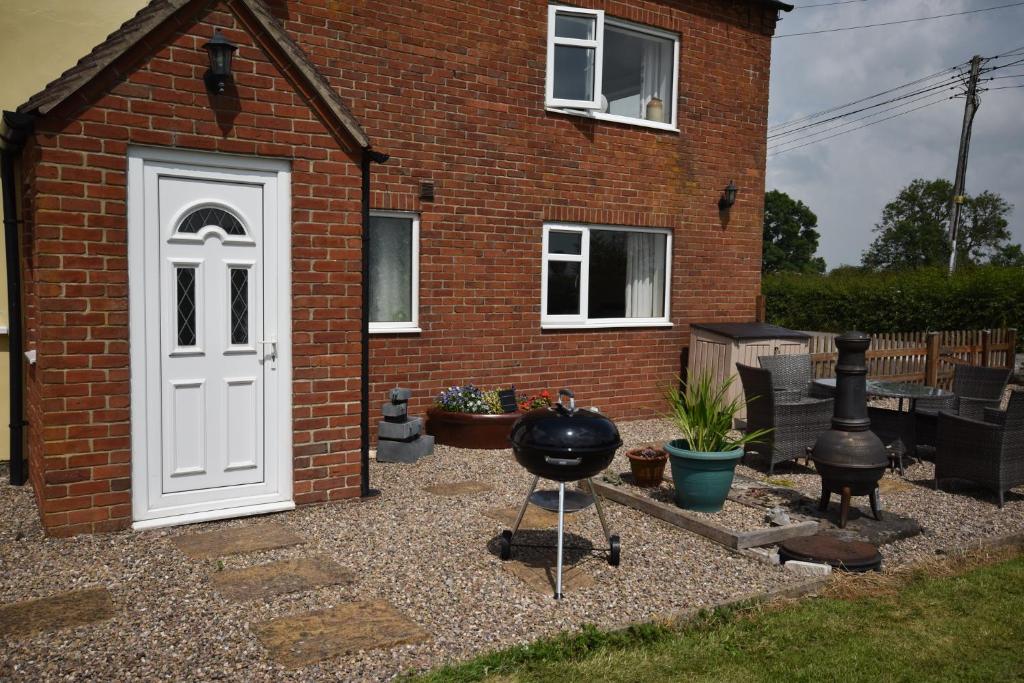 a barbecue grill in front of a brick house at The Cottage, Poplars Farm in Ashbourne