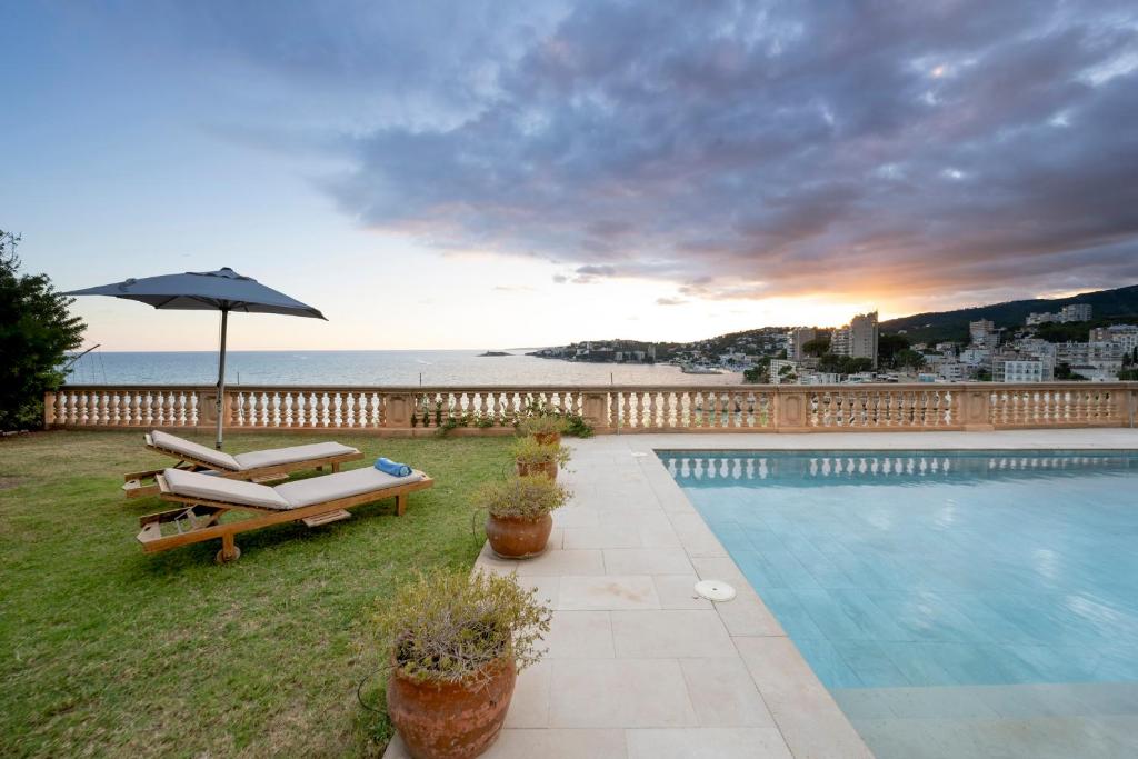 a swimming pool with an umbrella and some chairs and an umbrella at Mirador Ca'n Rovira in Palma de Mallorca