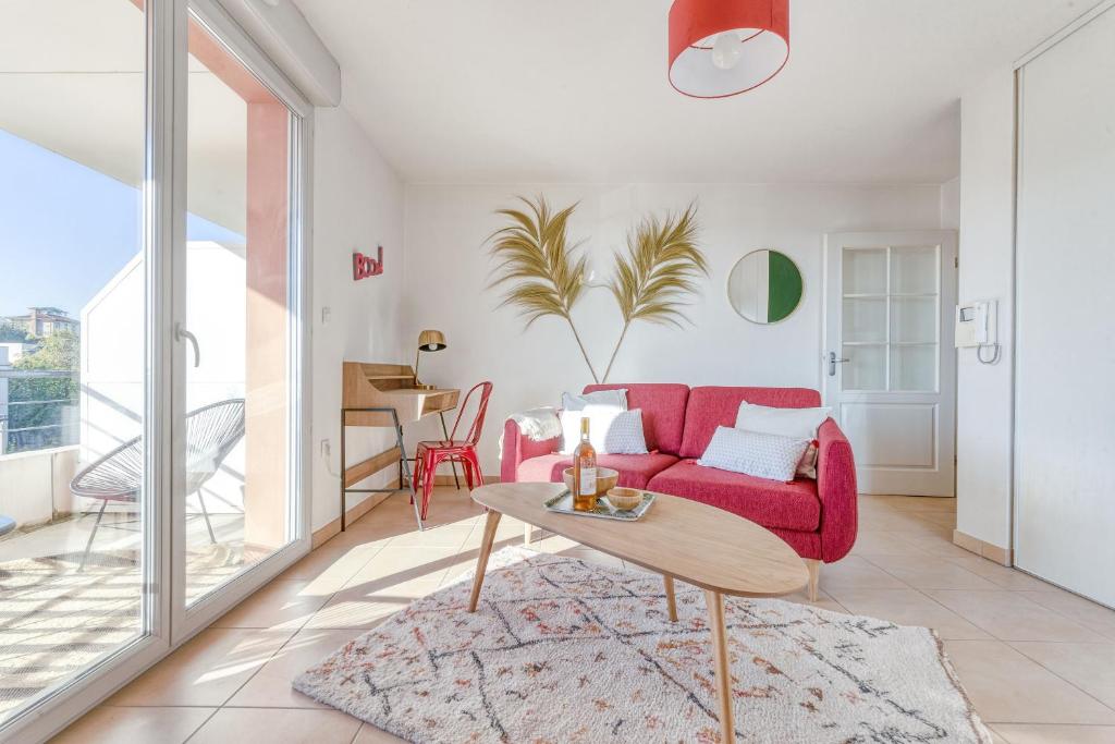 圖盧茲的住宿－La Rosace，客厅配有红色的沙发和桌子