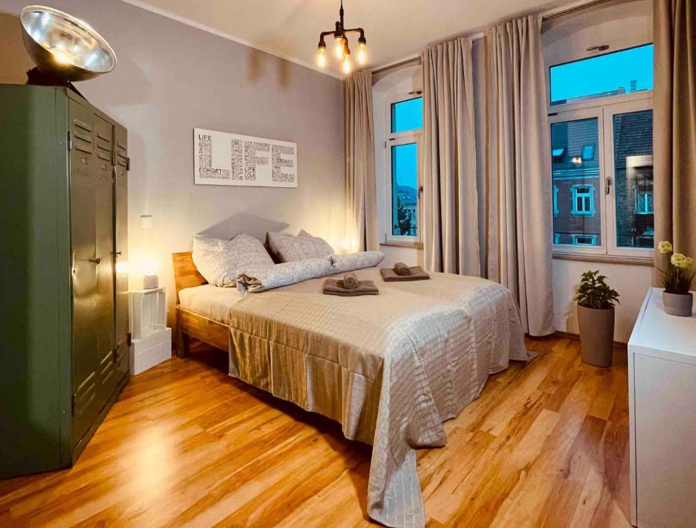 a bedroom with a bed and a large window at Edle Ferienwohnung - Industrial Style in Dresden