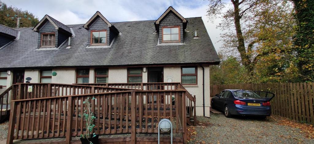 una casa con un coche aparcado junto a una valla en Ben Lomond Cottage, en Arrochar