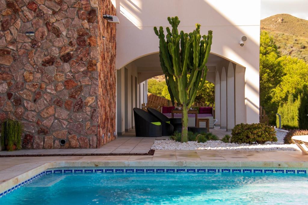 a house with a swimming pool and a stone wall at Oro y luz las negras in Las Negras