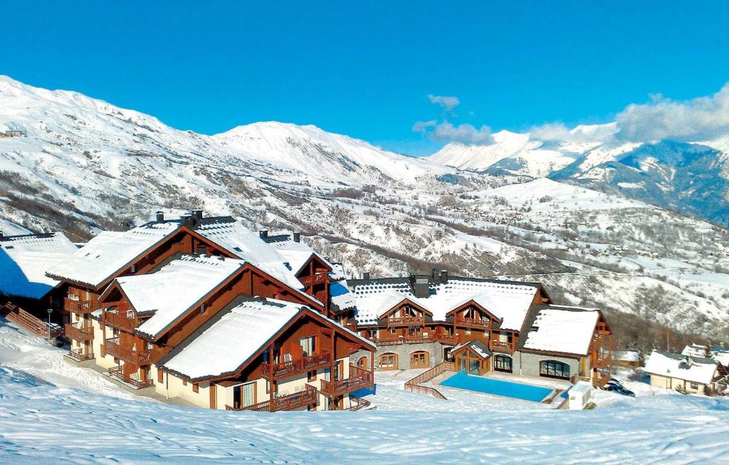 eine Lodge im Schnee mit Bergen im Hintergrund in der Unterkunft Résidence Goélia Les Alpages du Corbier in Villarembert