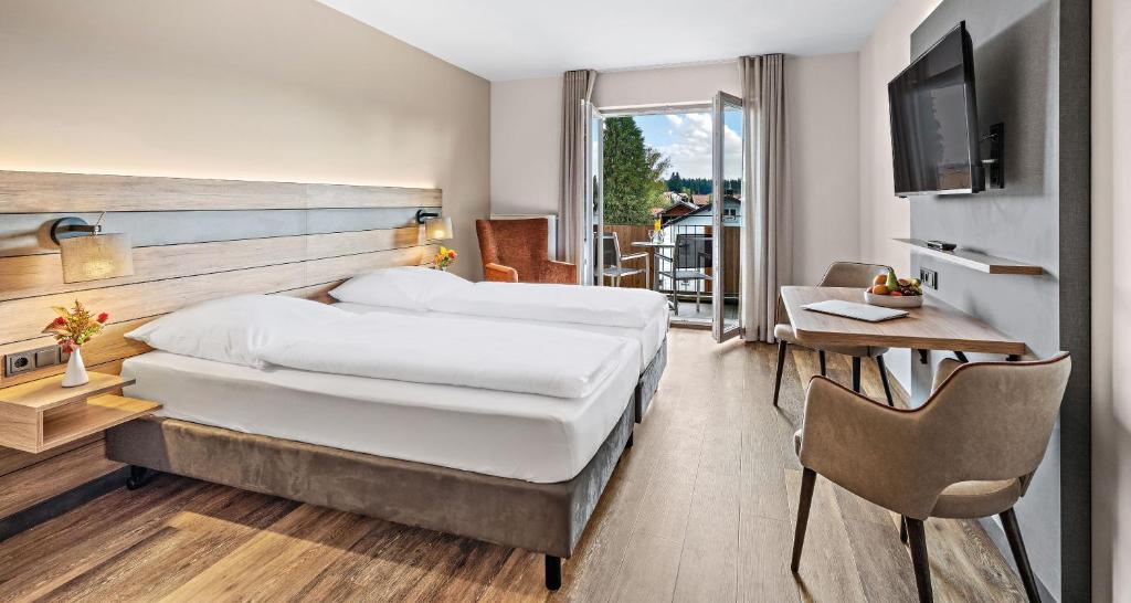 ObingにあるHotel Seeblickのベッド2台とバルコニーが備わるホテルルームです。