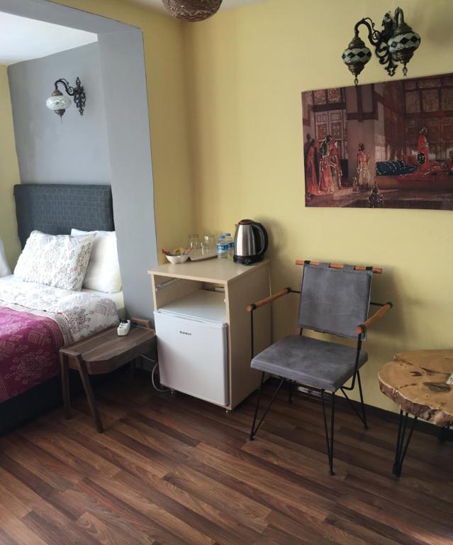 Marmara House&Apartments في إسطنبول: غرفة نوم بسرير وكرسي وطاولة