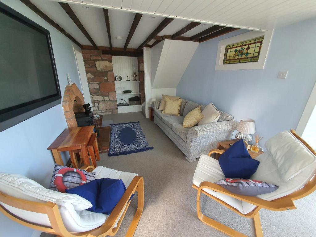 un soggiorno con 2 sedie e un divano di Cromla Cottage a Corrie