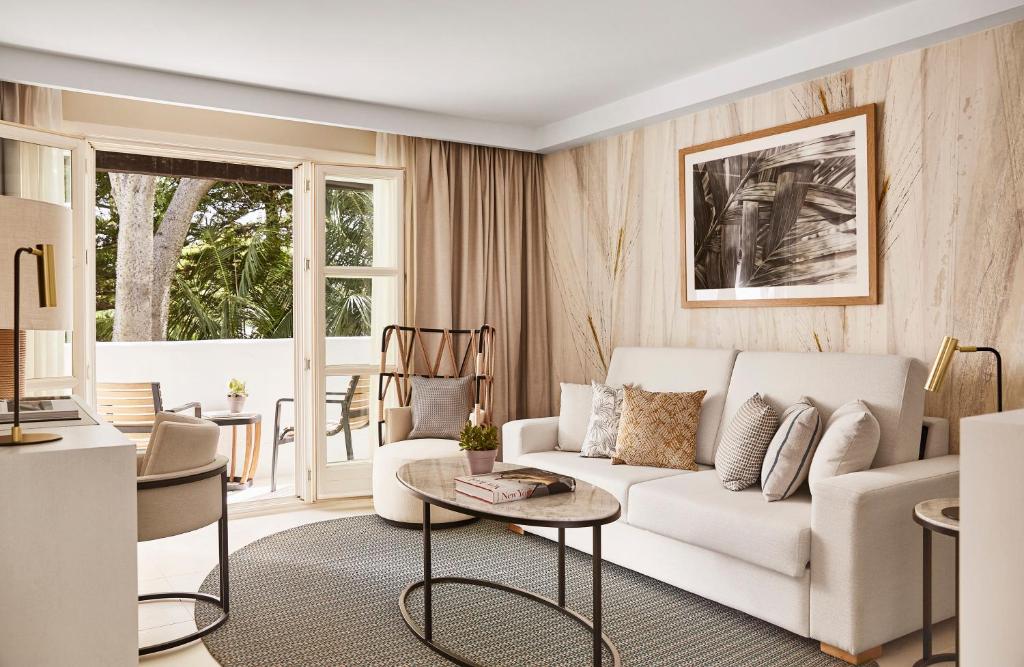 a living room with a white couch and a table at Puente Romano Marbella in Marbella