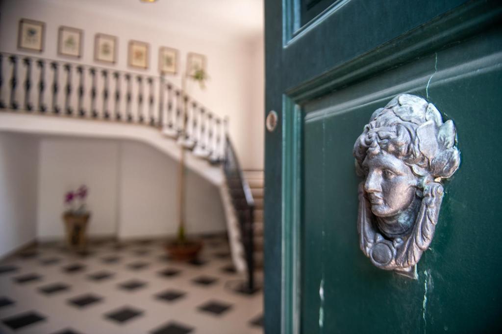 una puerta verde con un busto de una mujer en ella en Florence Trevelyan Villa, en Letojanni