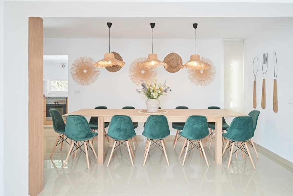 a dining room with a table and green chairs at New y Cute Bóvedas Playa den Bossa in Ibiza Town