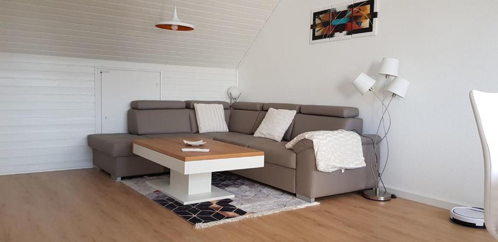 ein Wohnzimmer mit einem Sofa und einem Tisch in der Unterkunft Drosselnest Moderne Design-Wohnung Hier ist alle neu! in Minden