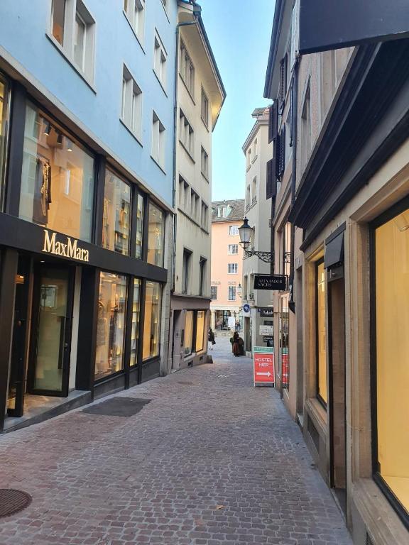 an empty street in a city with buildings at Friendly Hostel Zürich in Zürich