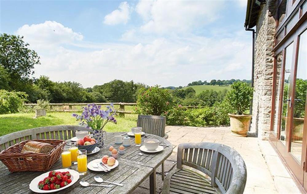 a wooden table with food and drinks on a patio at Host & Stay - Tregaer Mill Barn in Dingestow