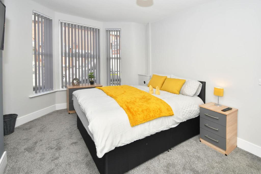 a bedroom with a bed with a yellow blanket on it at Townhouse @ Lawton Street Crewe in Crewe