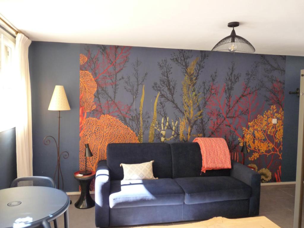 - un salon avec un canapé et un tableau mural dans l'établissement LE LOGIS DU PALAIS, à Marseille
