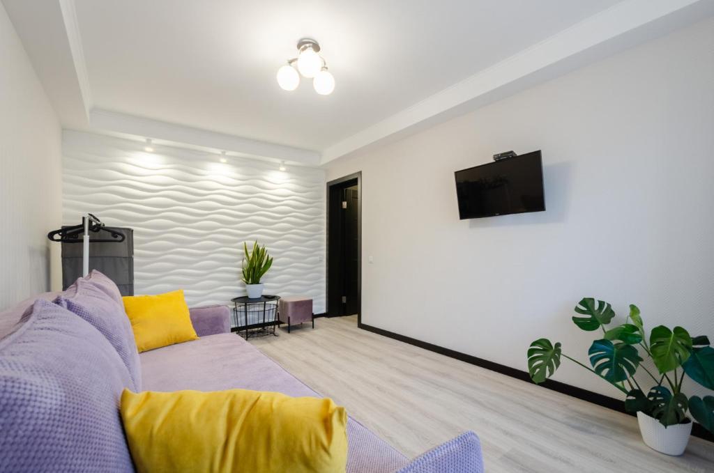 een woonkamer met een paarse bank en gele kussens bij ARTAL Apartment on Obolonskyi Avenue 16 in Kiev