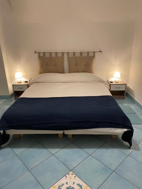 een slaapkamer met een groot bed met 2 nachtkastjes bij Atri Guest House in Napels