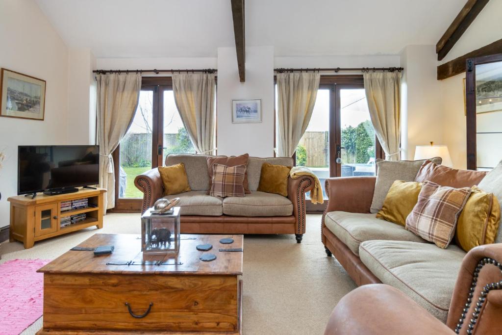 a living room with couches and a coffee table at The Old Stables in Yeovil