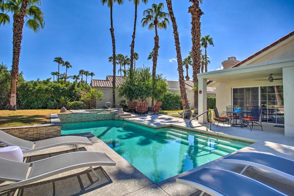 ein Pool mit Stühlen und ein Haus mit Palmen in der Unterkunft Desert Retreat - Walk to Indian Wells Tennis in Palm Desert