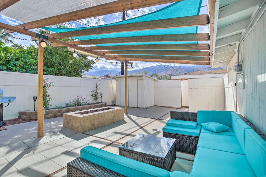 une terrasse avec un canapé bleu et une pergola dans l'établissement Stunning Palm Springs Home with Private Yard!, à Palm Springs