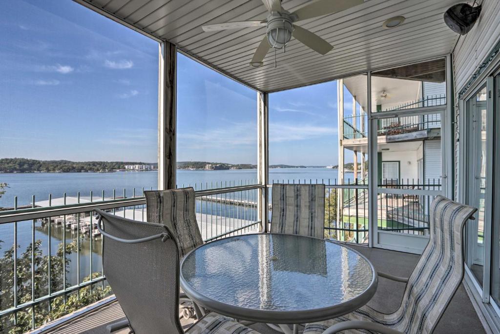 een tafel en stoelen op een balkon met uitzicht op het water bij Lake Ozark Condo with Boat Slip and Pool Access! in Lake Ozark