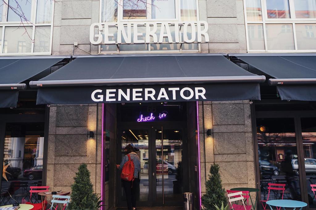 una persona parada fuera de una tienda con un toldo azul en Generator Berlin Mitte, en Berlín