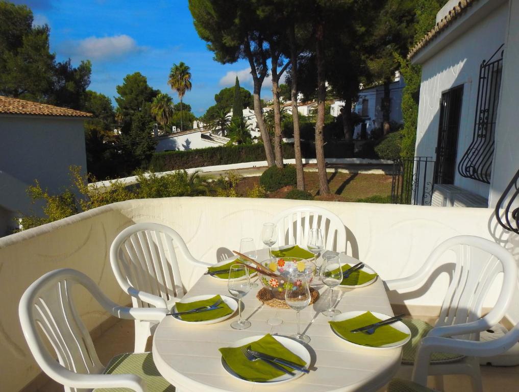 una mesa blanca con servilletas verdes y gafas. en Calle Alberca 5, Villotel. Madroñal Urb., 03726 Benitachell,, en Teulada