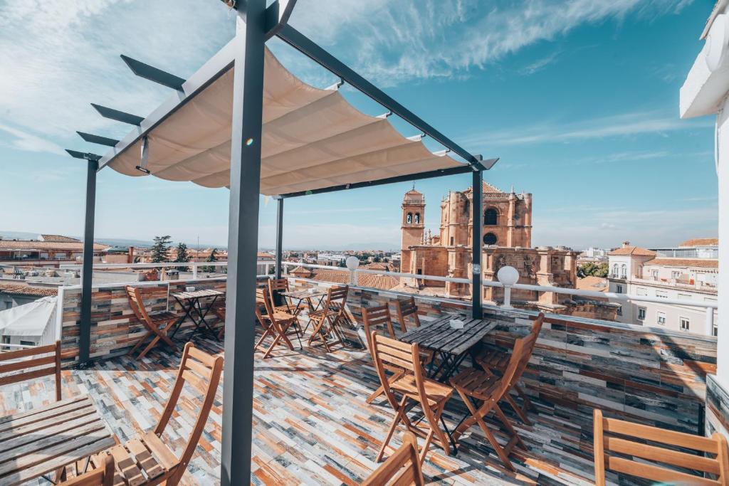 グラナダにあるHotel Monasterio Granada - Adults Onlyの椅子とテーブル付きの建物の屋根からの眺め