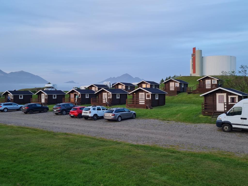 una fila de casas con autos estacionados en un estacionamiento en Höfn Cottages en Höfn