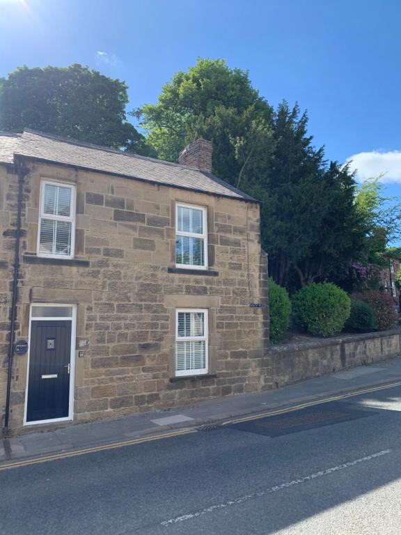 une maison en briques sur le côté d'une rue dans l'établissement Rose Cottage, à Morpeth