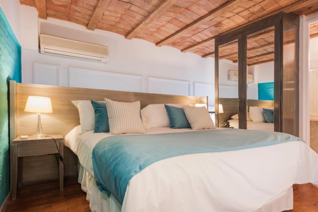 a bedroom with a large bed with blue and white pillows at San Telmo Suites in Buenos Aires