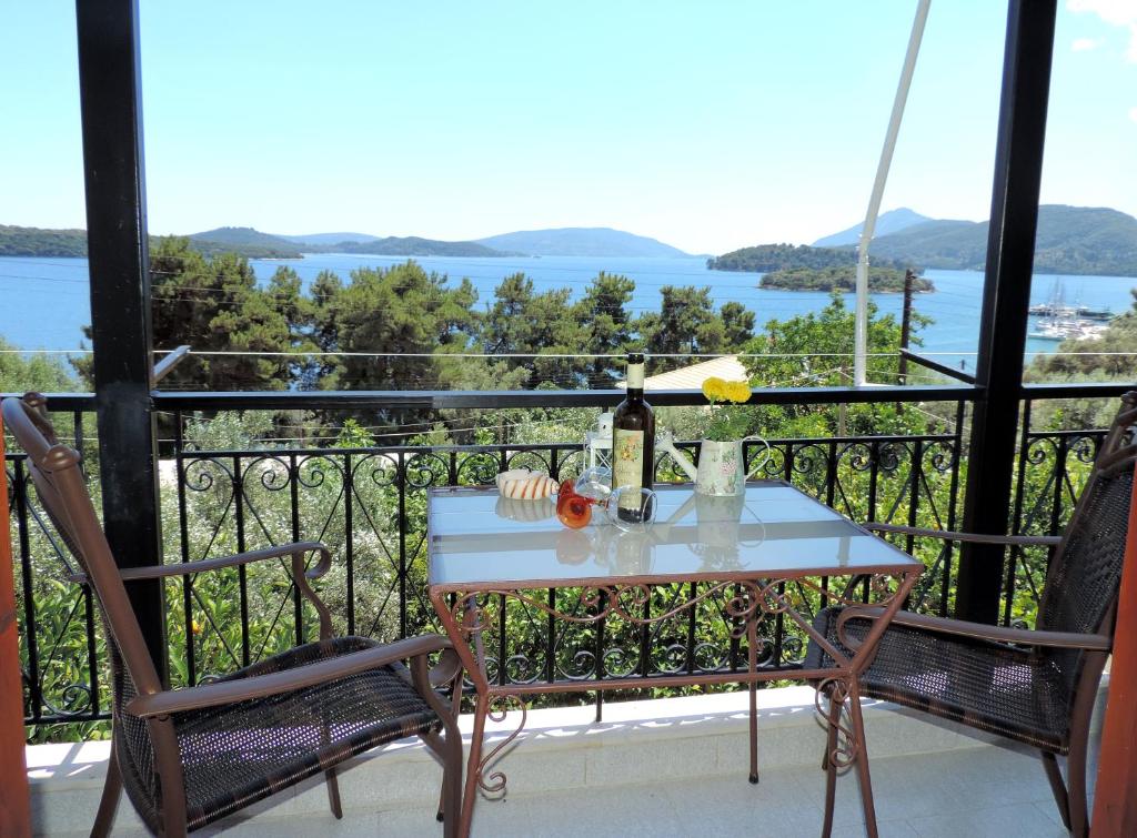 a table with a bottle of wine on a balcony at Argyros Studios in Nydri