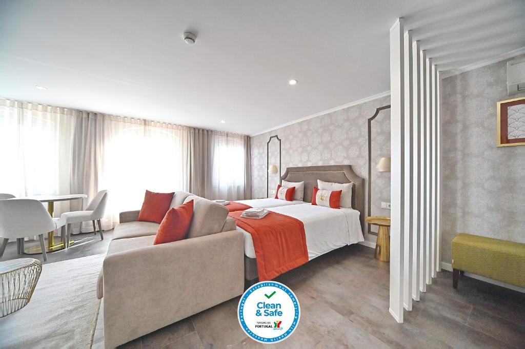 ein Hotelzimmer mit einem Bett und einem Sofa in der Unterkunft Famous Crows Lisbon Suites in Lissabon