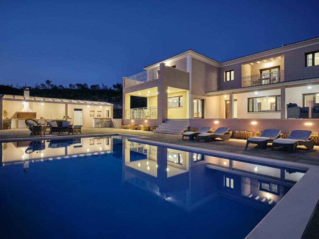 una casa con piscina por la noche en Karousa Villa - Karousa Villas Anafonitria Zakynthos, en Anafonítria