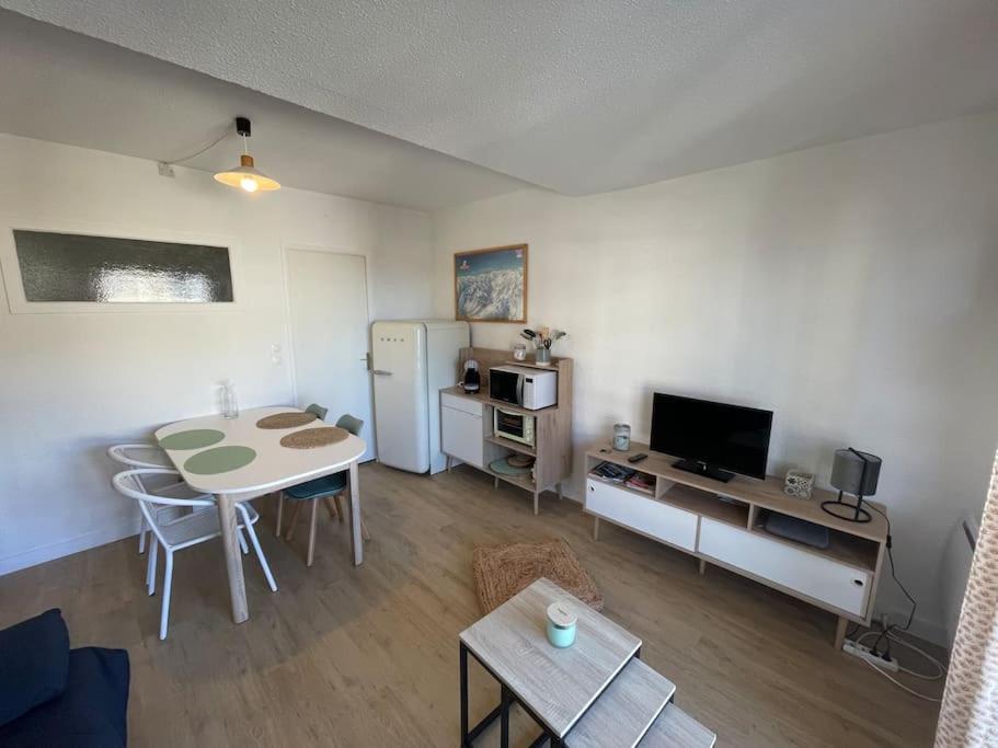 ein kleines Wohnzimmer mit einem Tisch und einer Küche in der Unterkunft T2 pla d'adet au pied des pistes in Saint-Lary-Soulan